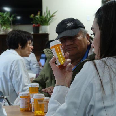 Student inspecting a patient&#039;s medication bottle
