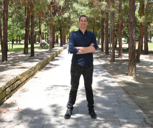 Tony Capra, PhD, on sidewalk between rows of trees