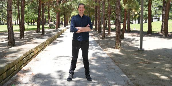 Tony Capra, PhD, on sidewalk between rows of trees